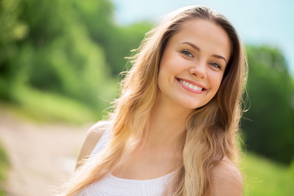 blonde woman with shoulder length hair and trimmed eyebrows vitamins